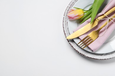 Photo of Stylish table setting with cutlery and tulip on white background, flat lay. Space for text