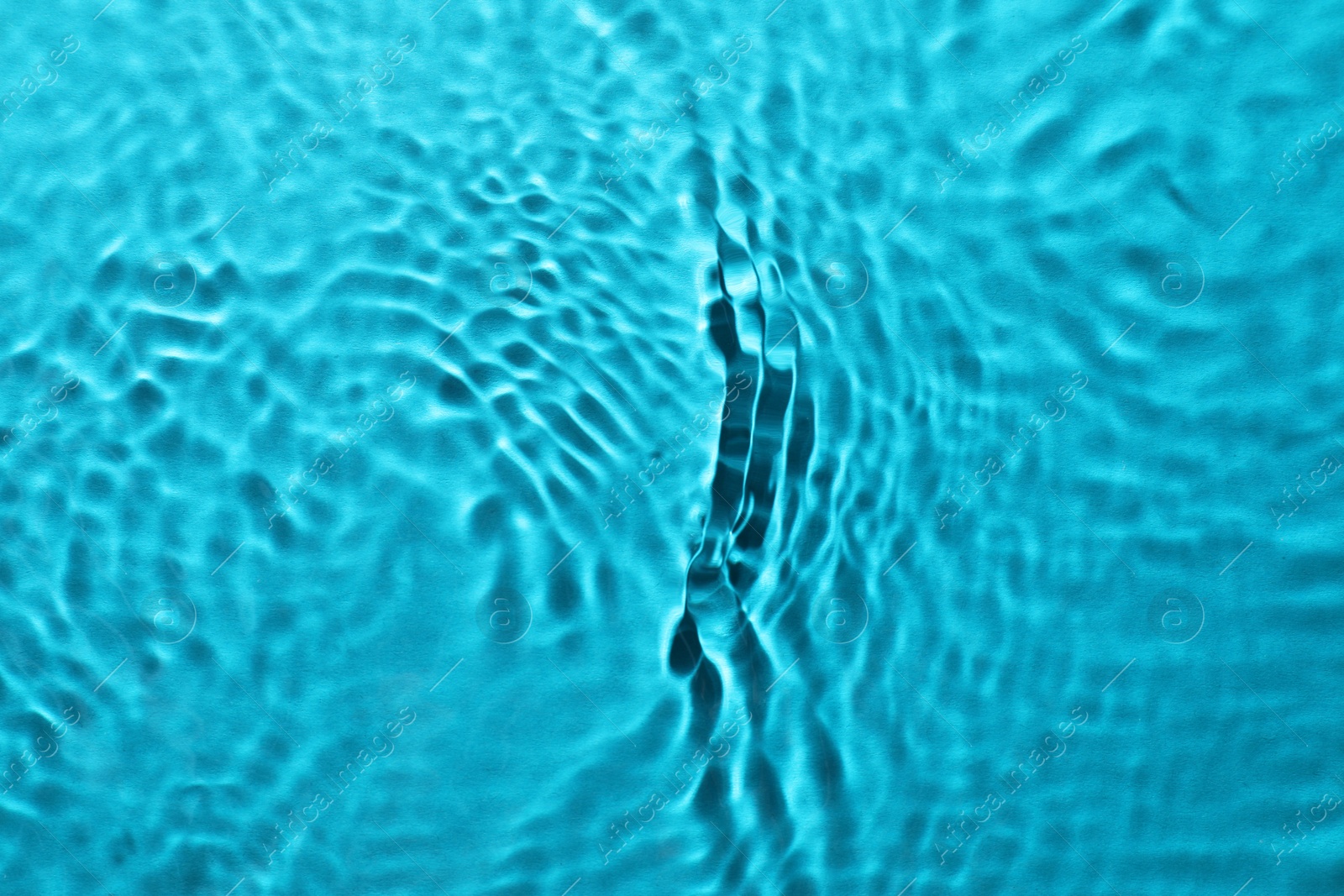 Photo of Rippled surface of clear water on light blue background, top view