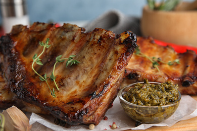 Tasty grilled ribs with thyme served on table, closeup