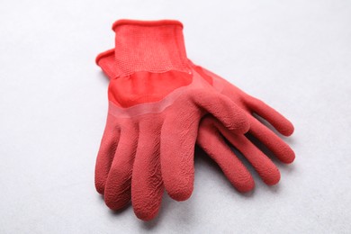 Photo of Pair of red gardening gloves on light grey table