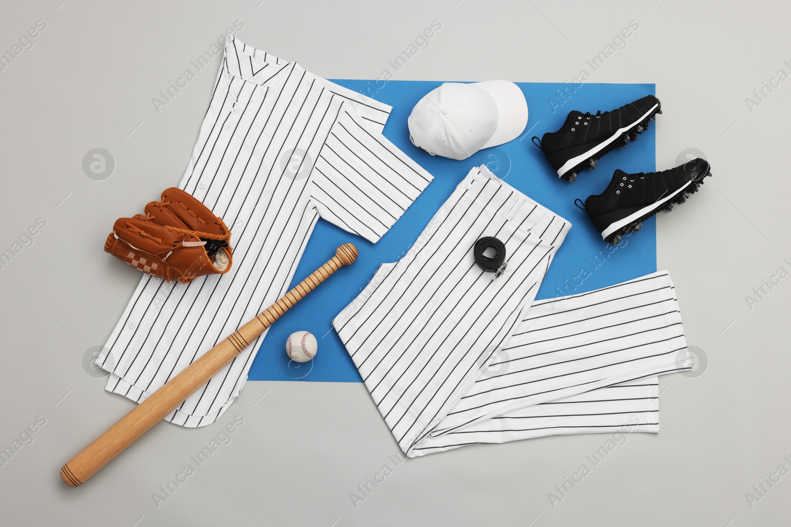 Photo of Flat lay composition with baseball uniform and sports equipment on color background