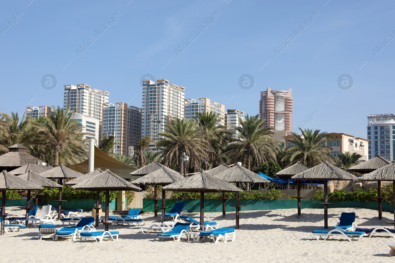 Photo of SHARJAH, UNITED ARAB EMIRATES - NOVEMBER 04, 2018: Sandy beach with umbrellas on sunny day