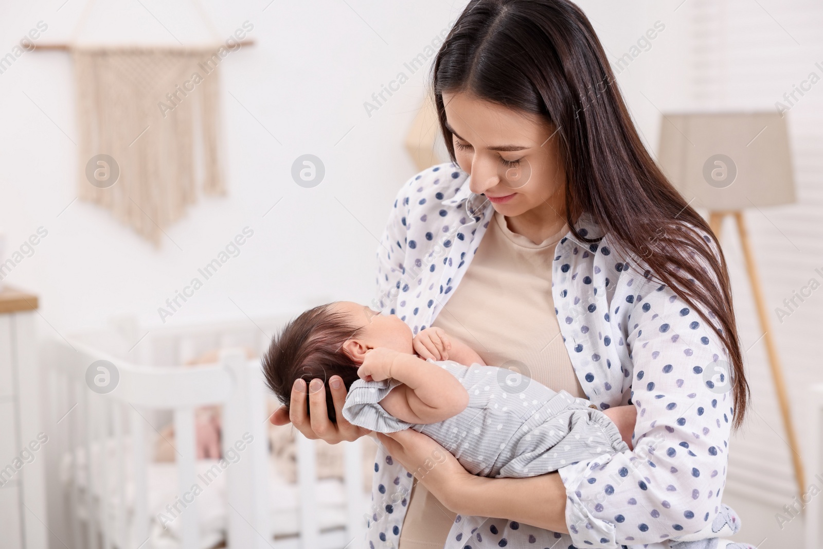 Photo of Mother with her sleeping newborn baby at home