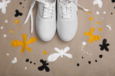 Photo of White sneakers on color background, flat lay. Customized shoes