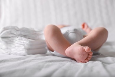 Photo of Little baby lying at bed, focus on legs