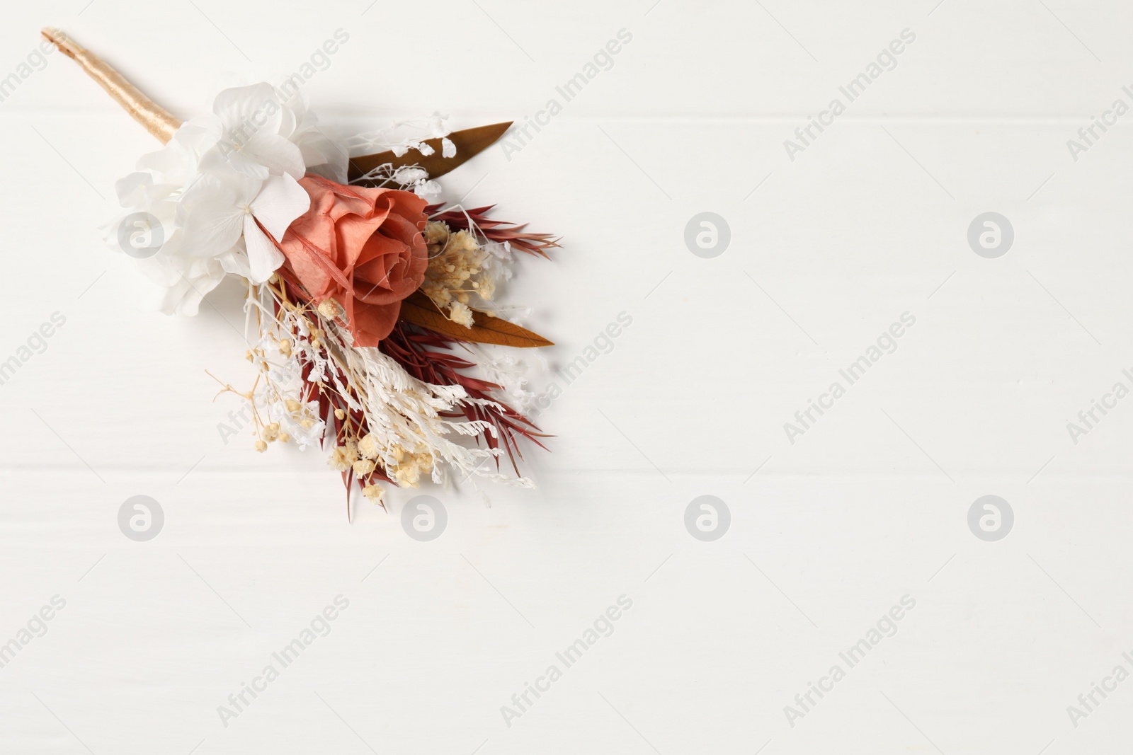 Photo of Beautiful boutonniere on white background, top view. Space for text