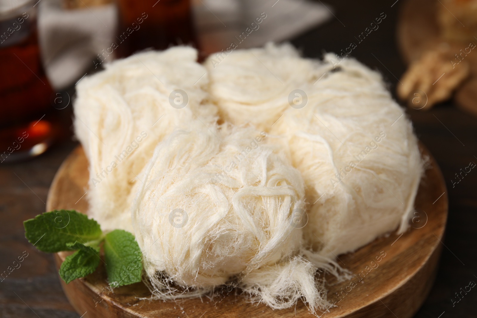 Photo of Eastern sweets. Tasty Iranian pashmak on wooden table, closeup