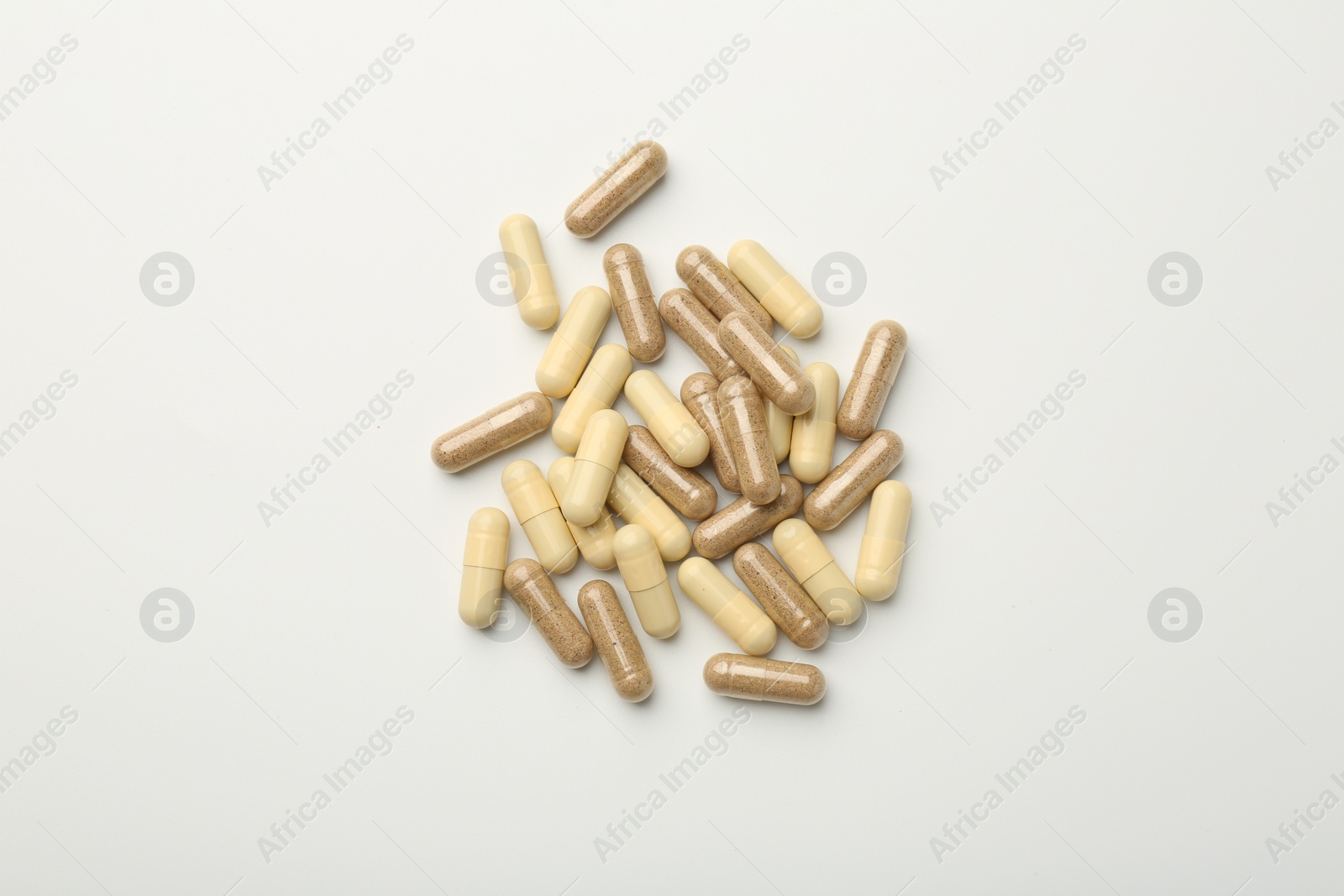 Photo of Different vitamin capsules on white background, top view