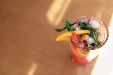 Photo of Refreshing natural lemonade with mint and orange in glass on table. Detox drink