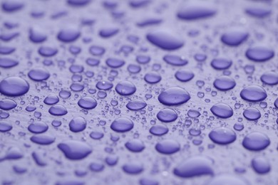 Water drops on lilac background, closeup view