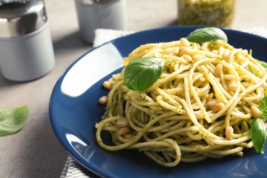 Photo of Plate of delicious basil pesto pasta on table, closeup