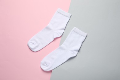 Photo of Pair of white socks on color background, flat lay
