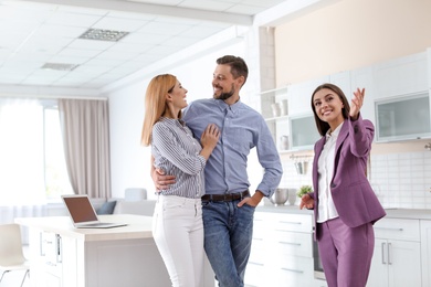 Female real estate agent showing new house to couple, indoors