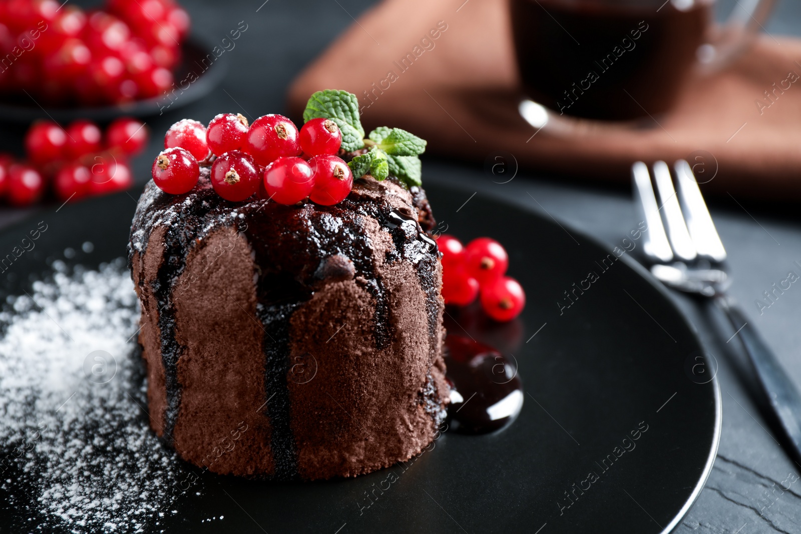 Photo of Delicious warm chocolate lava cake with mint and berries on table, closeup