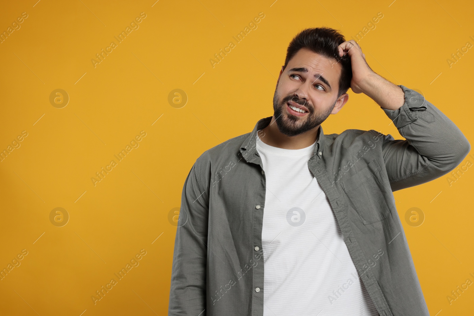 Photo of Embarrassed man on orange background. Space for text