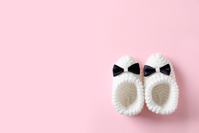 Photo of Handmade baby booties on color background, top view with space for text