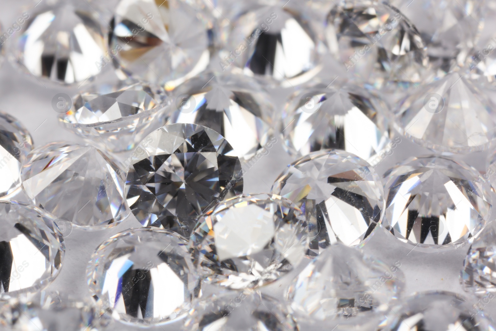 Photo of Many beautiful shiny diamonds on light background, closeup