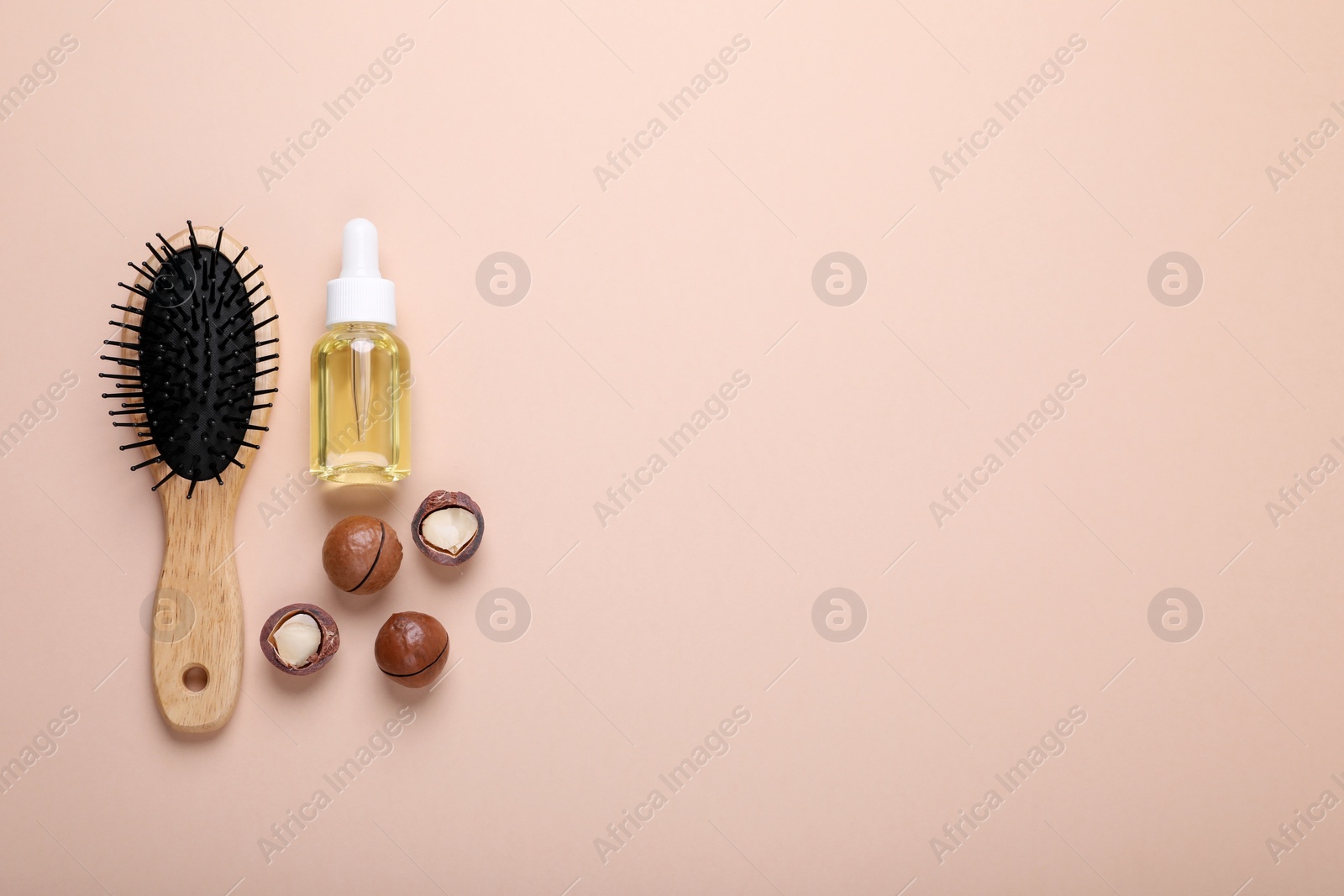 Photo of Delicious organic Macadamia nuts, cosmetic oil and brush on beige background, flat lay. Space for text