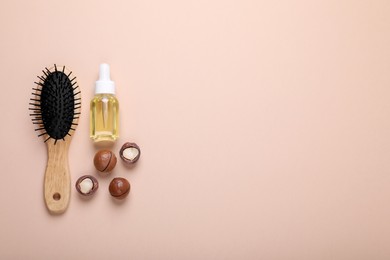 Delicious organic Macadamia nuts, cosmetic oil and brush on beige background, flat lay. Space for text