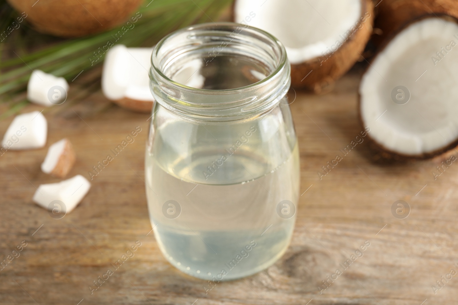 Photo of Coconut oil on wooden table, closeup view