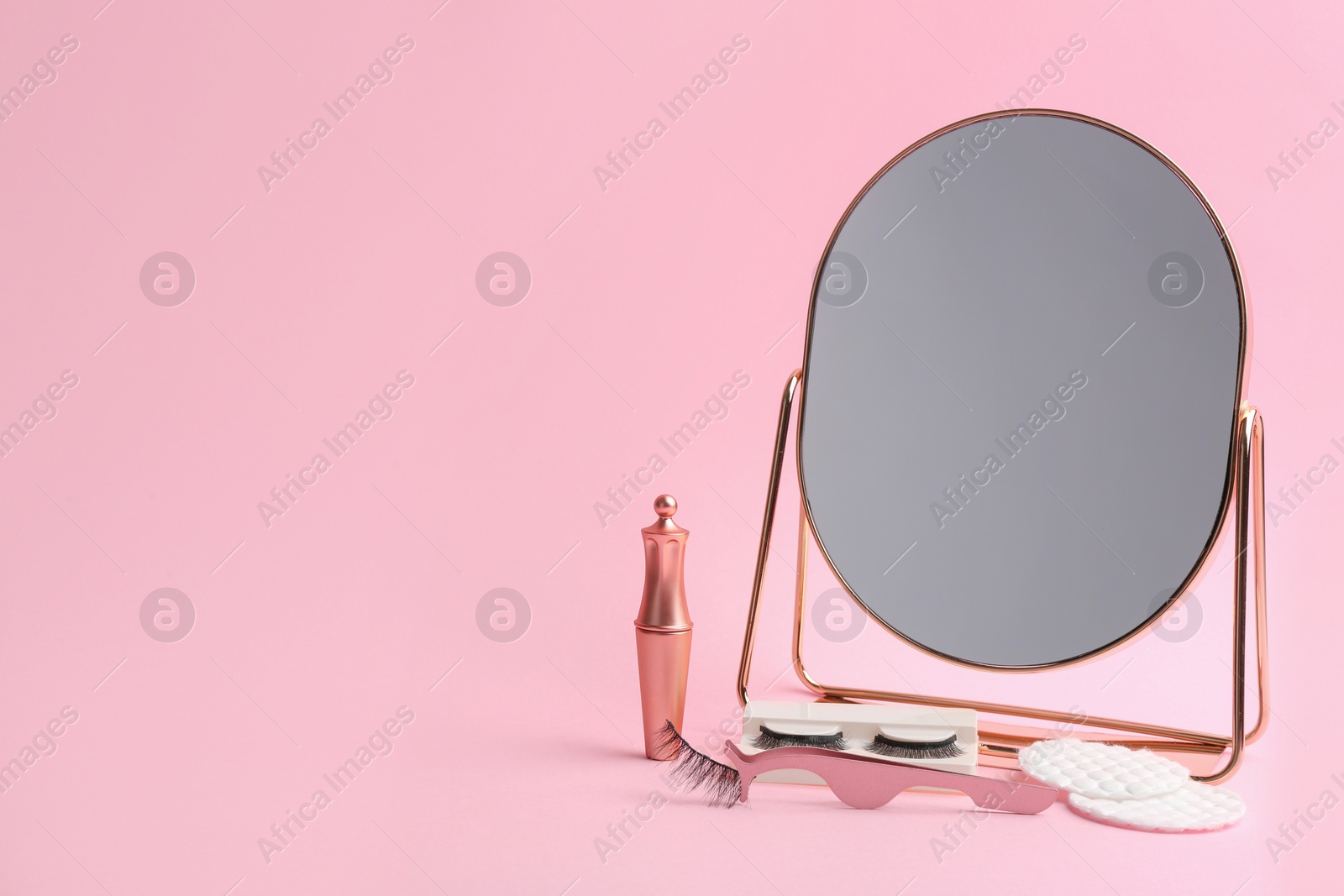 Photo of Magnetic eyelashes and accessories on pink background. Space for text