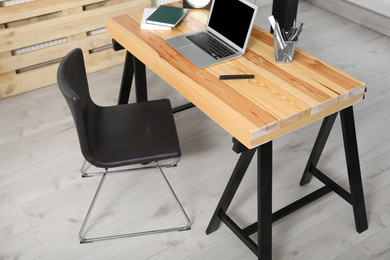 Photo of Comfortable workplace with office chair and wooden table