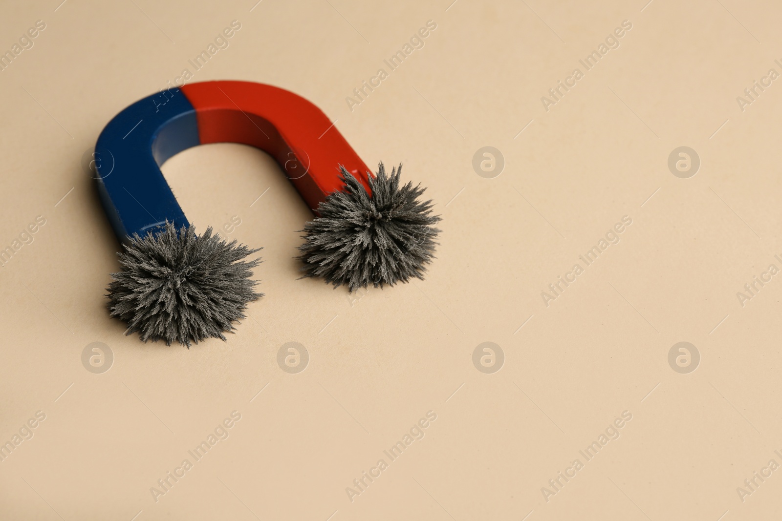 Photo of Magnet with iron powder on color background. Space for text