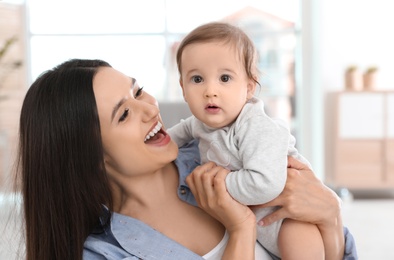 Photo of Portrait of young mother and her adorable baby at home