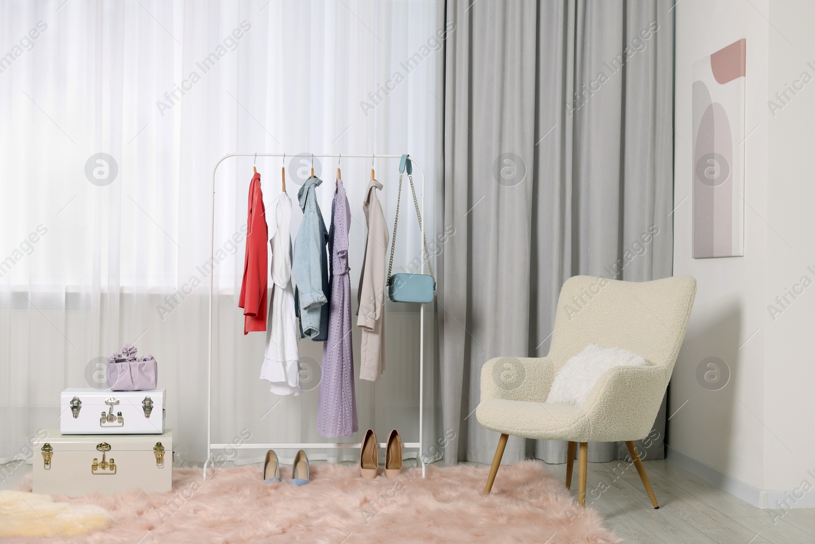 Photo of Clothing rack with stylish women's clothes on hangers in boutique