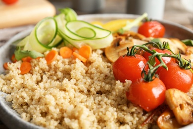 Photo of Plate with healthy quinoa salad and vegetables, closeup