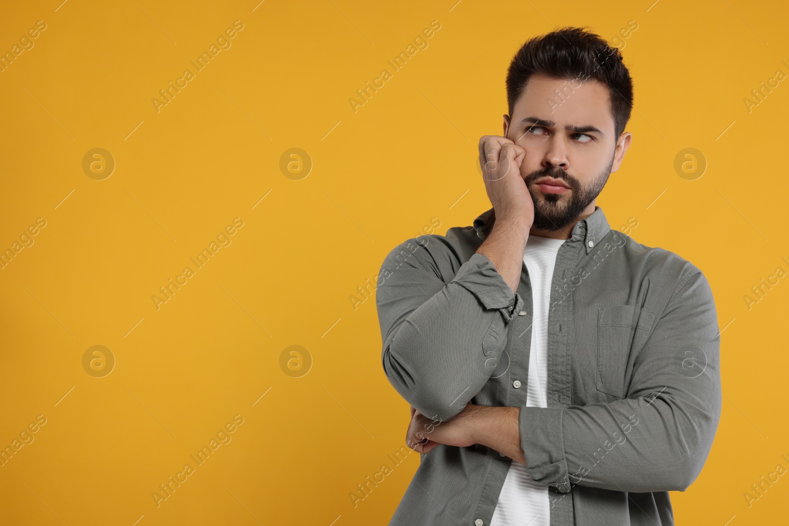 Photo of Resentful man on orange background. Space for text