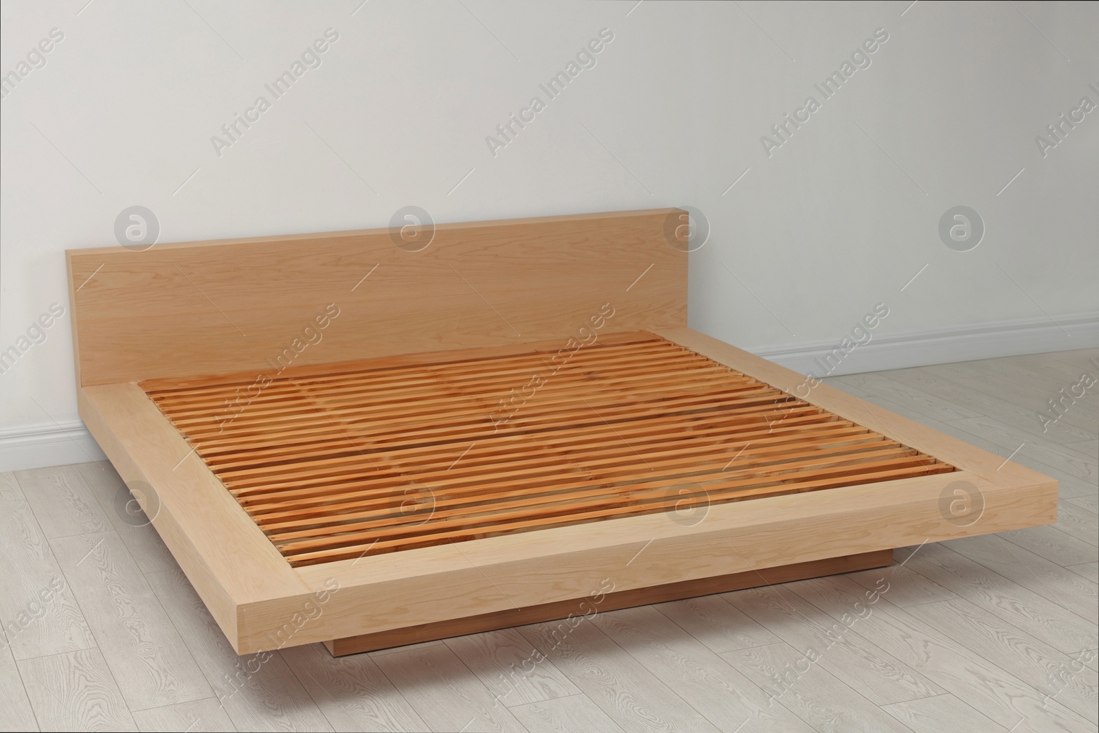 Photo of New wooden bed frame in empty room