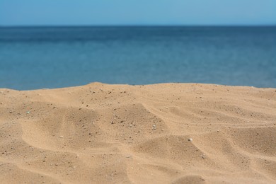 Photo of Closeup view of sandy beach near sea on sunny day