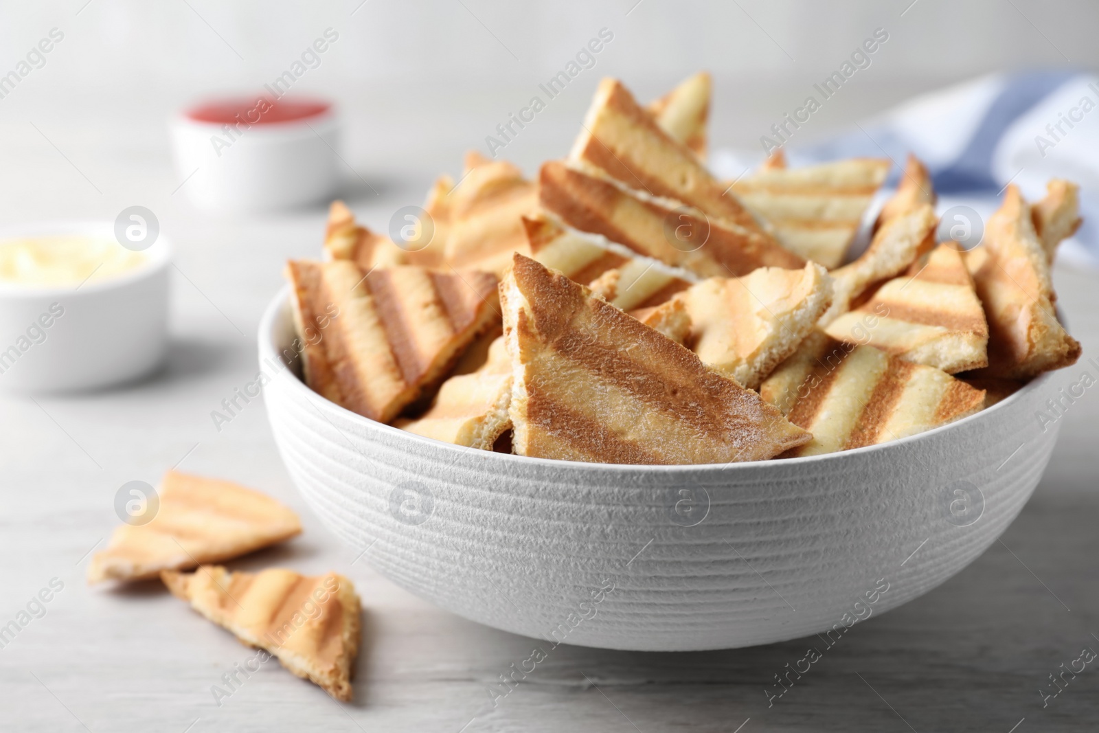 Photo of Delicious pita chips on white wooden table