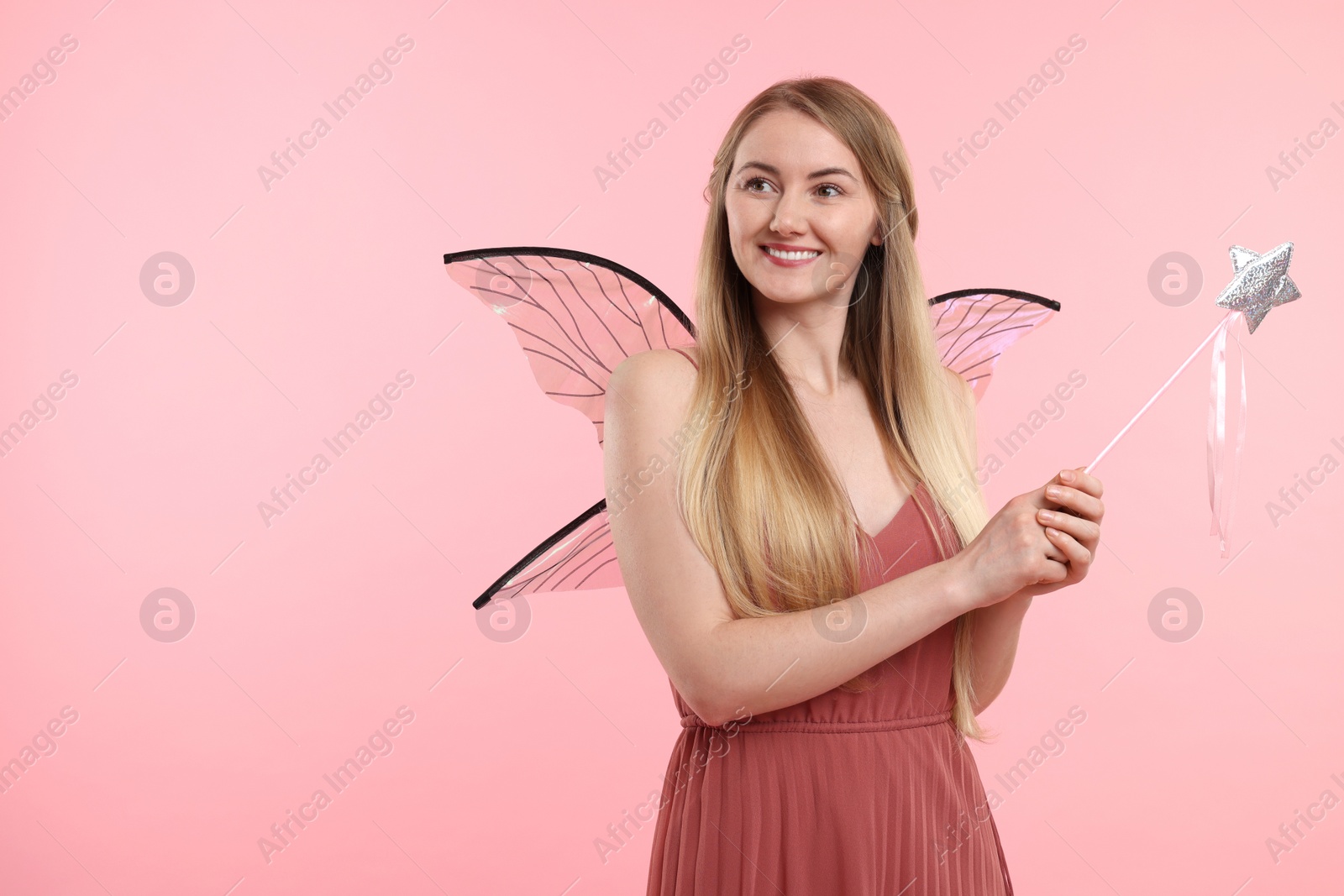 Photo of Beautiful girl in fairy costume with wings on pink background, space for text