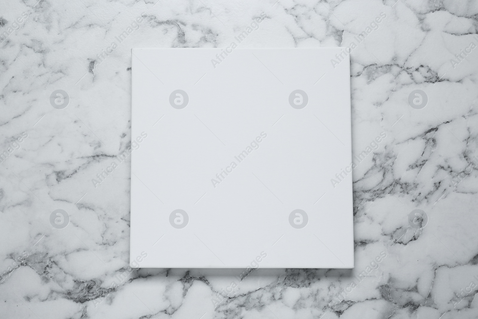 Photo of Blank canvas on white marble background, top view. Space for design