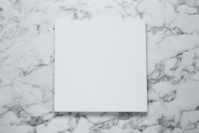 Blank canvas on white marble background, top view. Space for design
