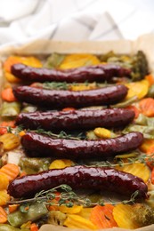 Photo of Delicious smoked sausages and baked vegetables on table, closeup