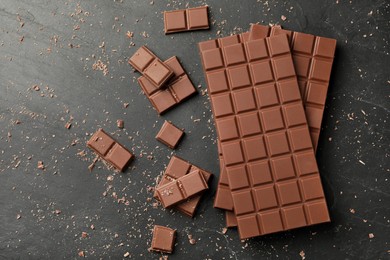 Pieces of tasty chocolate on grey table, flat lay