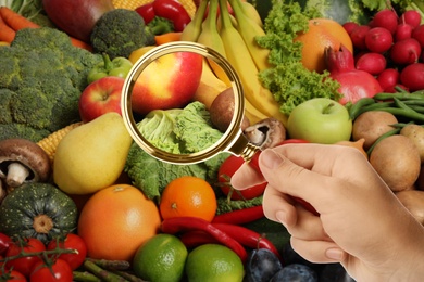 Image of Woman with magnifying glass focusing on cabbage and apple, closeup. Food control 