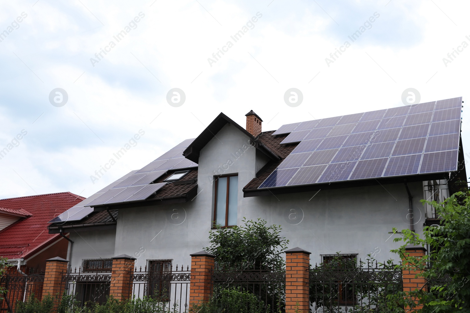 Photo of House with installed solar panels on roof. Alternative energy source