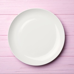 Photo of Stylish ceramic plate on pink wooden background, top view