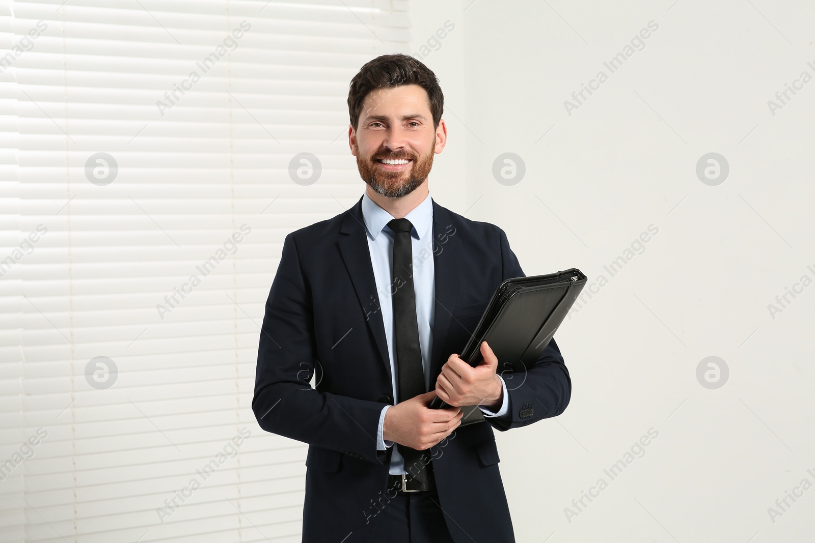 Photo of Handsome real estate agent with documents indoors