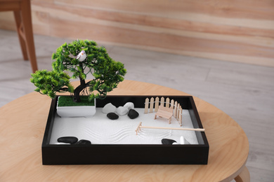 Beautiful miniature zen garden on wooden table indoors