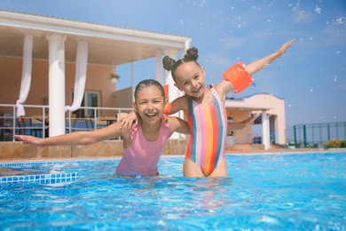 Photo of Cute little girls in swimming pool at water park
