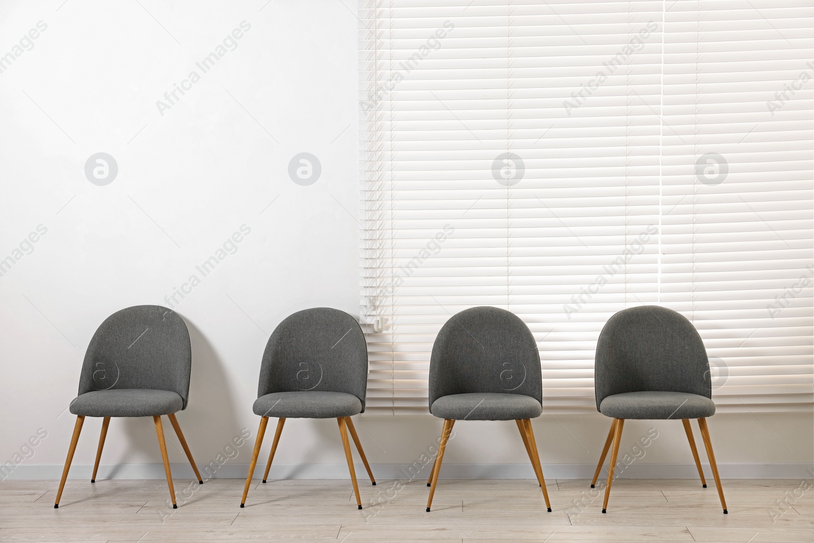 Photo of Many chairs near white wall in waiting area indoors