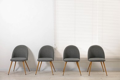 Photo of Many chairs near white wall in waiting area indoors