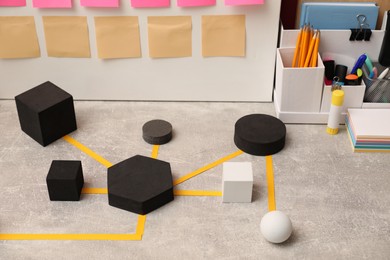 Business process scheme with geometric figures and stationery on light grey table