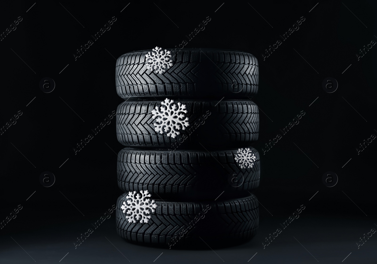 Image of Set of winter tires with snowflakes on black background