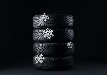 Image of Set of winter tires with snowflakes on black background